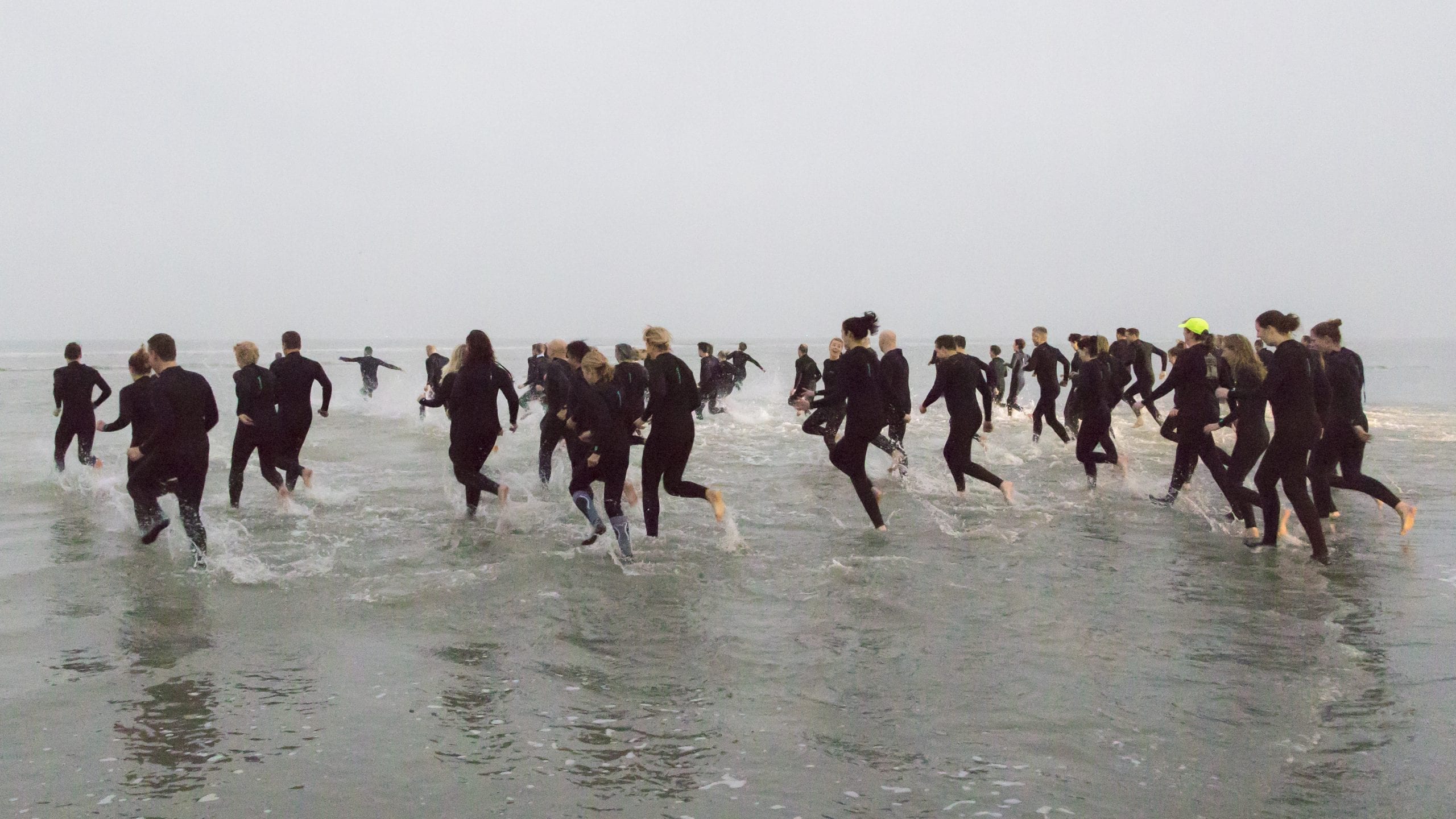 Landal medewerkers rennen de zee in tijdens bijeenkomst op het strand